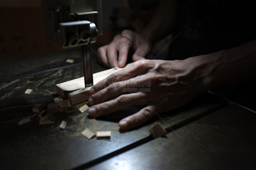 职业木匠建筑工与电动拼锯和木工人一起作切割块木头过程维护图片