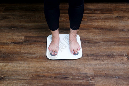 人类锻炼肥胖特写女脚踩体重秤控制减肥概念图片