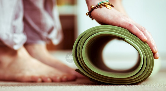 轧制训练妇女在家里做瑜伽垫子蓝色的图片
