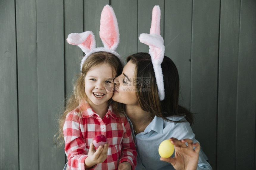 孩子美丽的亲吻女儿脸颊母兔子耳朵复活节图片