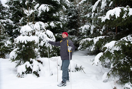 刨冰冬季男子与跨国滑雪者木材退缩图片