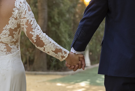 婚姻快乐的恋人新结婚幸福夫妇手握在公园走动图片