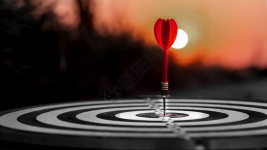 游戏户外自由红飞镖箭在日落背景下击中目标心电灯板商业定位和焦点概念图片