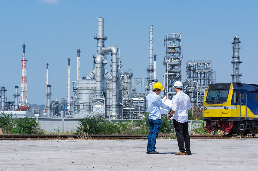 化学石工程师身着白头盔站在炼油厂背景上站立的炼油厂工程师白色的图片