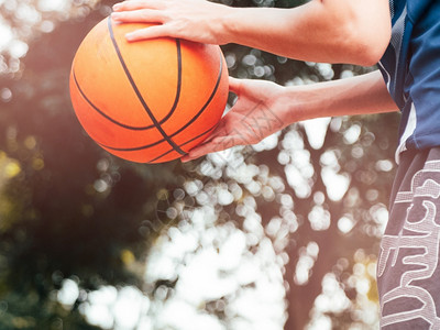 篮球篮圈一个拿着篮球的十几岁男孩准备在户外法庭把球扔进篮圈乐趣孩子背景