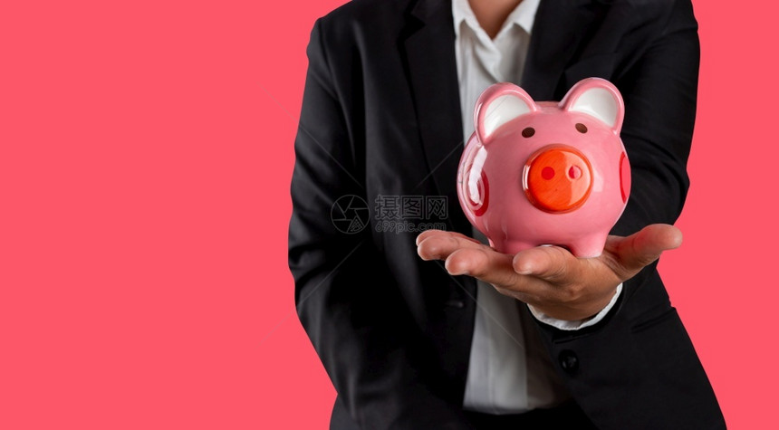 帐户金融规划概念持有手小猪银行的商人在红花粉上与世隔绝在职的粉色图片