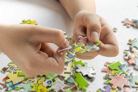 孩子玩拼图有色游戏学习带婴儿把手的拼图带彩色玩具拼图的Childrenrsquos手带婴儿把的早教拼图带彩色玩具拼图的背景