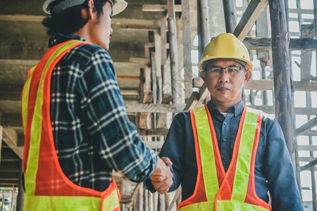 安全帽行业建造握手概念两个工程师握手关于工地建设的成功程项目图片