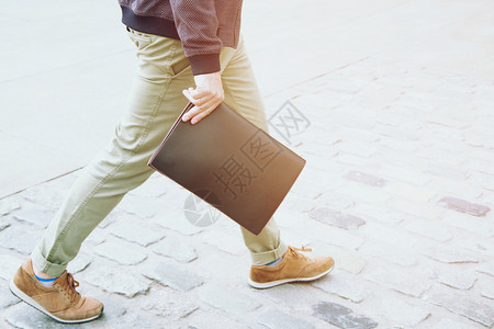 鞋类工作潮人身穿手戴公用文包的件袋在路上走街边的纸袋图片