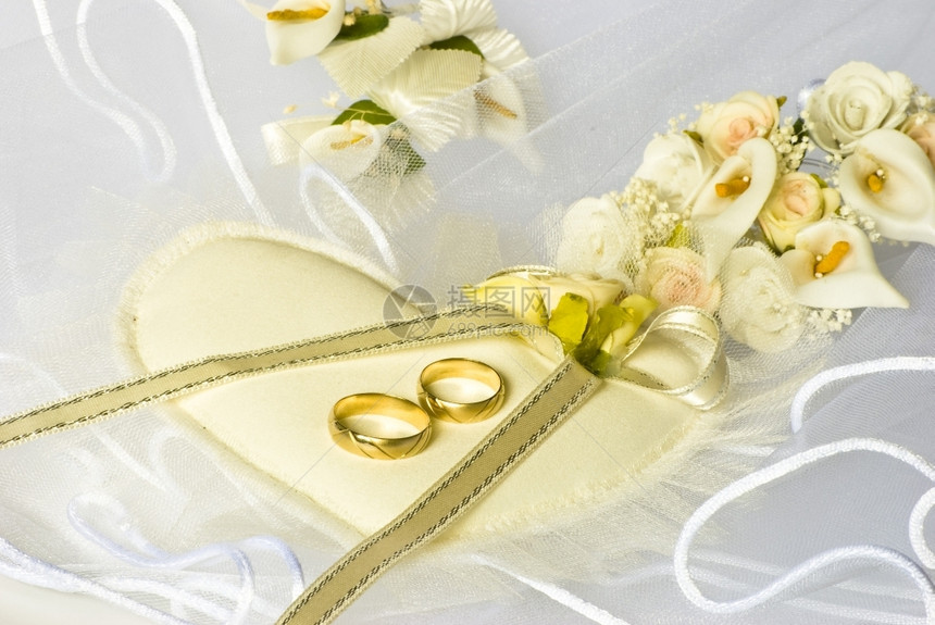 新娘面纱上的结婚戒指和鲜花装饰已婚金子百合图片