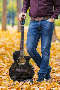 落叶地上拿着吉他的人图片