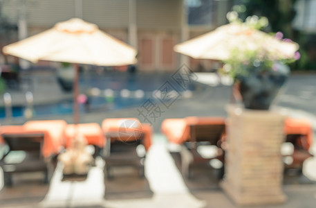 伞在旅馆度假胜地游泳池的阳光模糊背景反转过滤效果图象中摘要出去图片