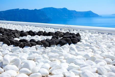 圣托里尼岛希腊Thira岛Sunny日黑石和白色块在露台海风岸白石和黑质地旅行海景背景图片