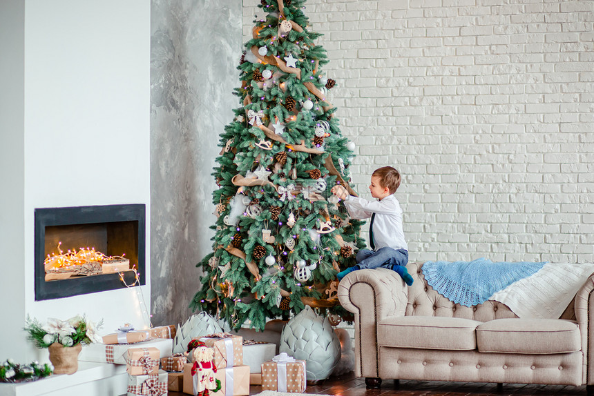 可爱的男孩用圣诞球装饰树下的礼物圣诞快乐可爱的男孩用圣诞球装饰树下的礼物毛衣假期婴儿图片