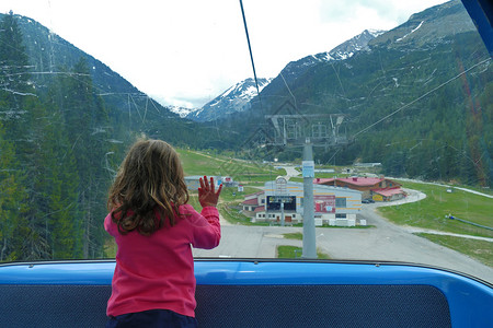 季节绿色小女孩在保加利亚班斯科看着滑雪电梯窗外的小姑娘孩子们图片