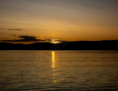 日落在湖面的阳光反射在湖面的水上日落阳光在森林后面黄昏美丽晴天图片