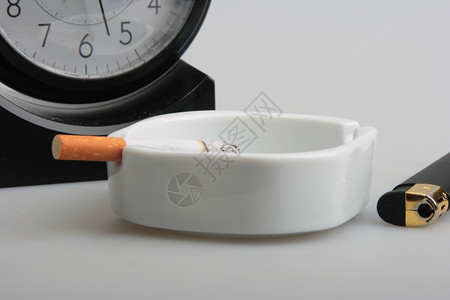 灰烟抽烟白色的时钟和烟灰缸配香摄影室背景