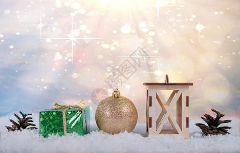 棕色的季节圣诞灯光背景夹锥圣诞玩具盒子和站在雪中的灯具笼图片
