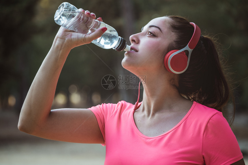 户外运动喝水的女性图片