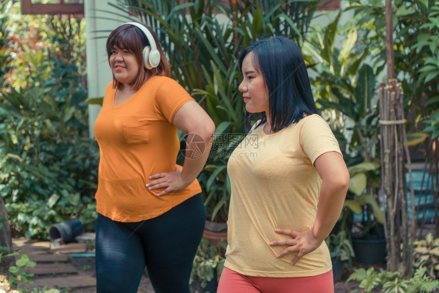 超重亚洲女在花园里与朋友运动概念一起工作以减肥和保持良好健康以及户外放松绿色图片