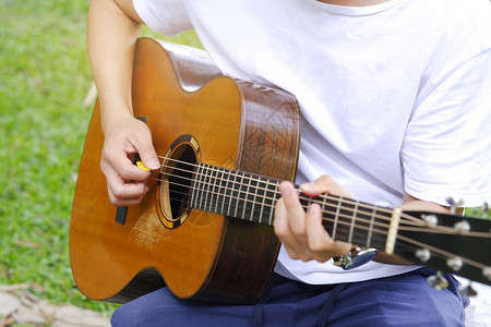 年轻人在花园里弹吉他图片