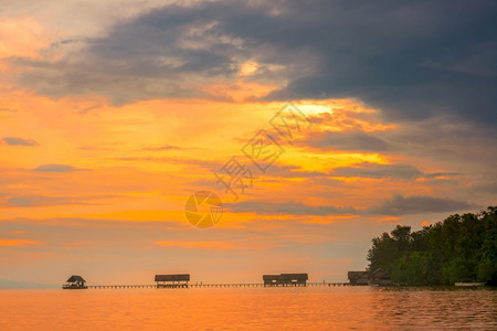 海景湖长桥一座码头和几小屋多彩的日落天空木林码头Huts和热带日落图片