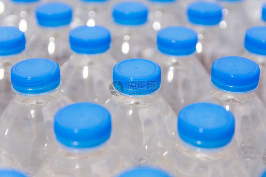 喝干净的一排水瓶带蓝盖的饮用水白色的图片