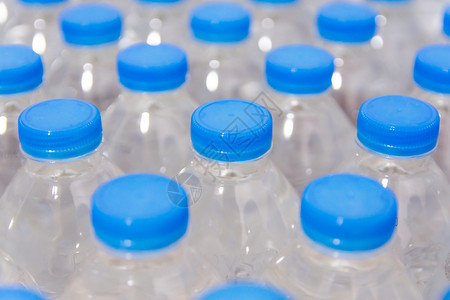 喝干净的一排水瓶带蓝盖的饮用水白色的图片