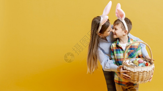 拥抱彩蛋年轻的快乐兔子带篮彩蛋的母亲背景