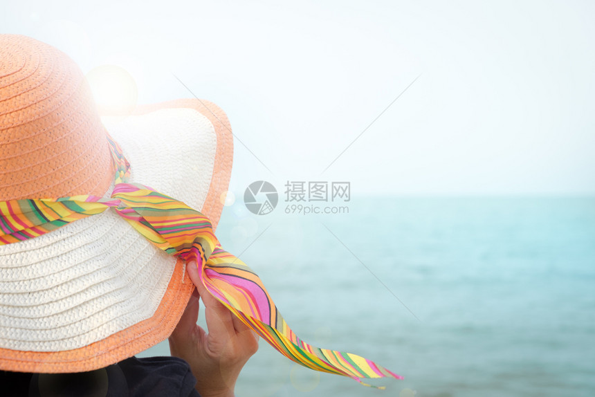 海滩遮阳板戴帽子的妇女在海边晒日光浴有复制空间和镜头跳蚤亚洲人图片