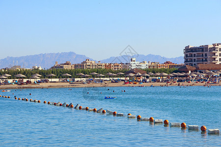 海洋浮标赫尔格达度假酒店全景从红海看赫尔格达旅游热带度假胜地人们在海中游泳旅理念人们在埃及度假胜地享受期度酒店全景休息夏天浮标背景