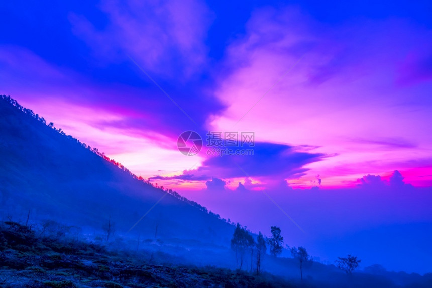 清晨在火山的斜坡上薄雾多彩的天空黎明前云在火山口的浮石上丰富多彩的黄昏辐射图片