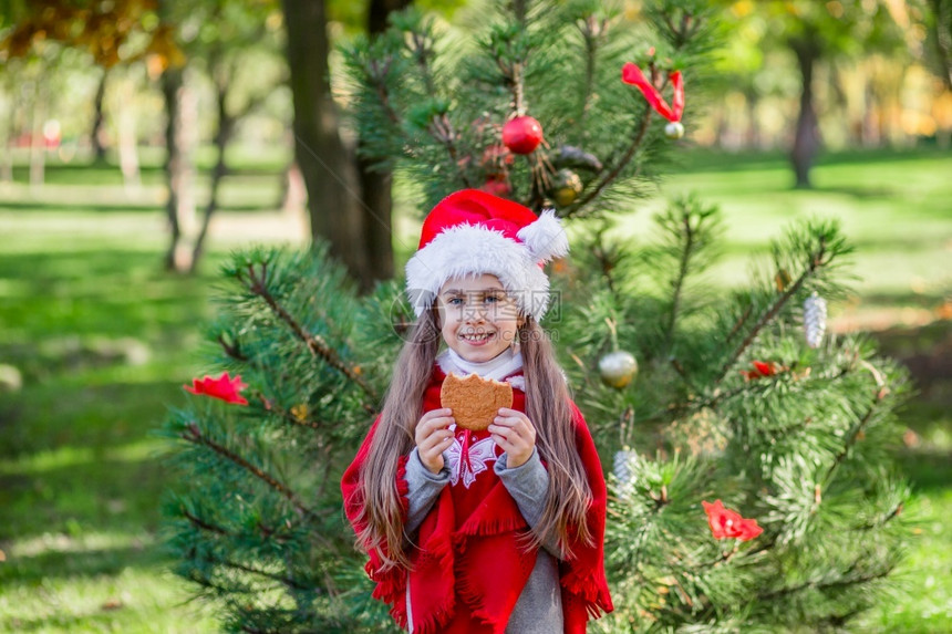 院子里装饰圣诞树的小女孩图片