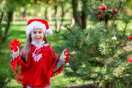 院子里装饰圣诞树的可爱女孩图片