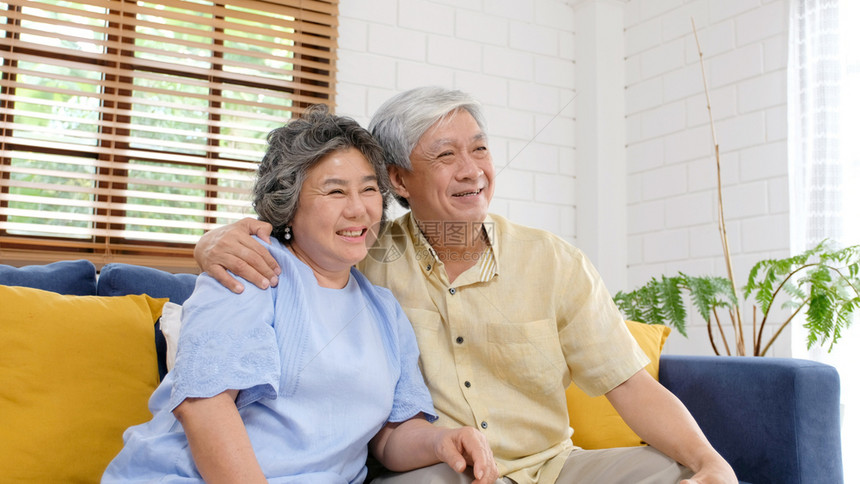 年长的亚裔夫妇在快乐的时刻家庭客厅背景人们情绪化退休片刻老年图片