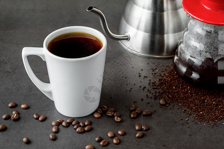 早餐画目的一杯咖啡和第三代倒在石地板上的咖啡酿制设备上图片