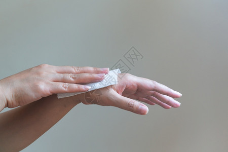 脸保持女人用白色纸巾来洗手孤立在白种背景的组织纸清除图片