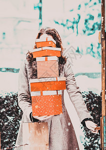 丝带帽子妇女从购物后回家时拿着成堆的圣诞礼物箱快乐的图片