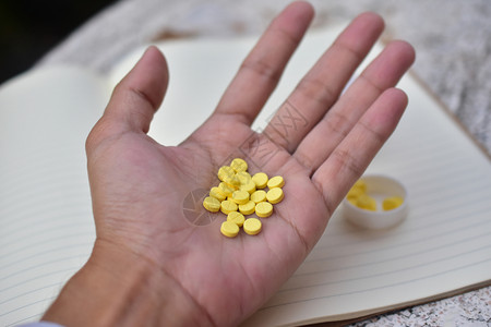 手里的黄色药品药片图片