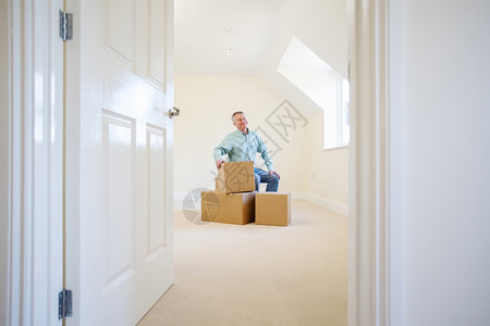 缩小规模辅助年长男子在搬家日靠新的盒子里安坐退休房间图片