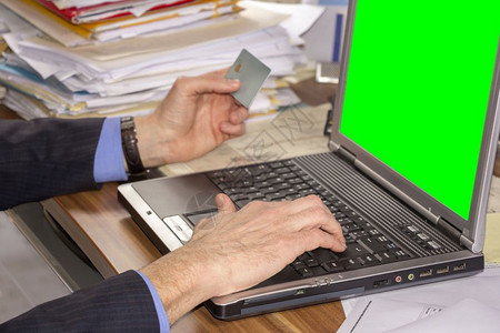 商人在网上购物使用笔记本电脑和绿屏信用卡技术触摸屏购买图片