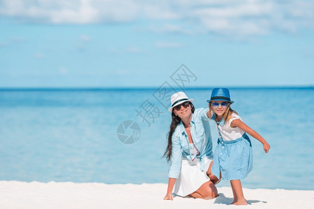 户外夏天小可爱女孩和年轻妈在热带海滩的妈还有女儿在海滩上图片