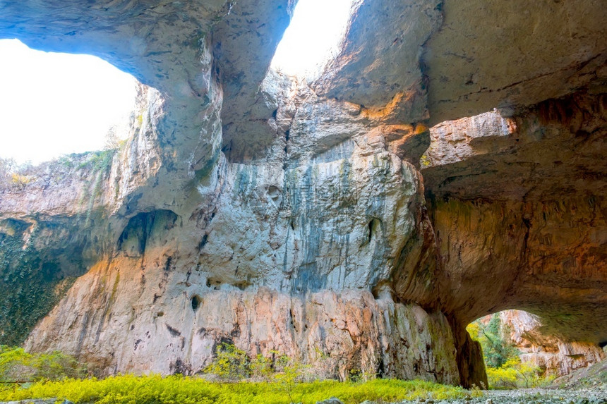神秘目的地老保加利亚洞穴Devetaki惊人的石头金库有洞绿色植被天花板上有一个洞图片
