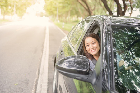 美丽的亚洲女在路上驾车旅行时微笑和愉快地开车乐趣白种人镜子图片