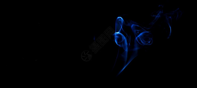 流动的黑暗色背景上蓝烟雾火灾设计黑色背景上的烟雾火灾设计艺术图片