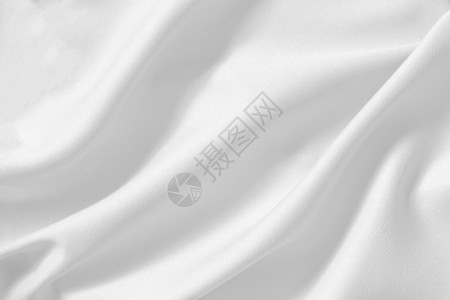 抽象的提苏折叠白棉布料纹理背景自然纺织无缝以软焦点为主的柔型天然纺织品模式白色光滑卷曲丝质条纹理背景作为复制背景图片