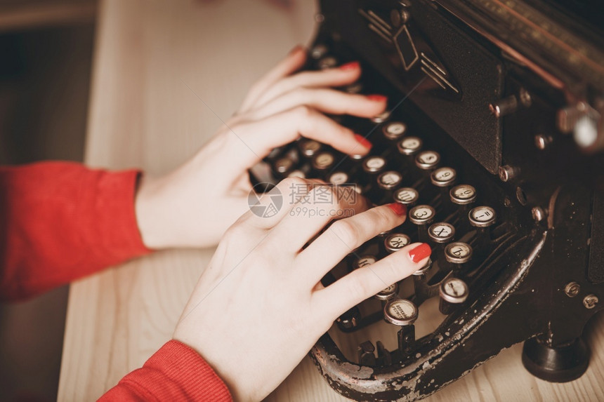 优质的使用打字机年轻妇女商业概念Retro图片风格旧打字机秘书电话红色的工作图片