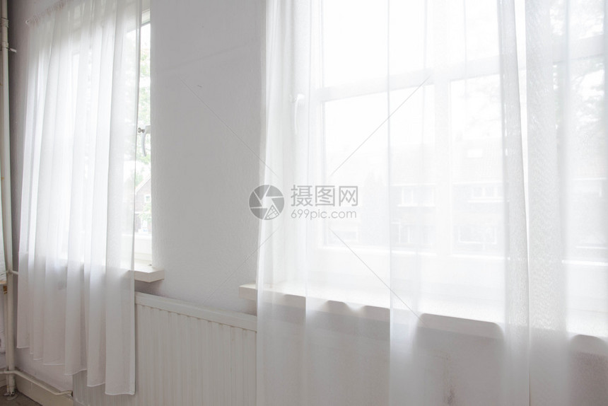 墙建筑学白色网帘靠在房子的两扇窗户上室内白色网帘靠在房子的两扇窗户上财产图片
