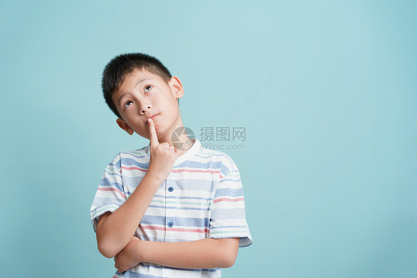 男亚洲小孩站在蓝背景的思考上孤立亚洲男人抬头寻找并复制空间肖像青年图片