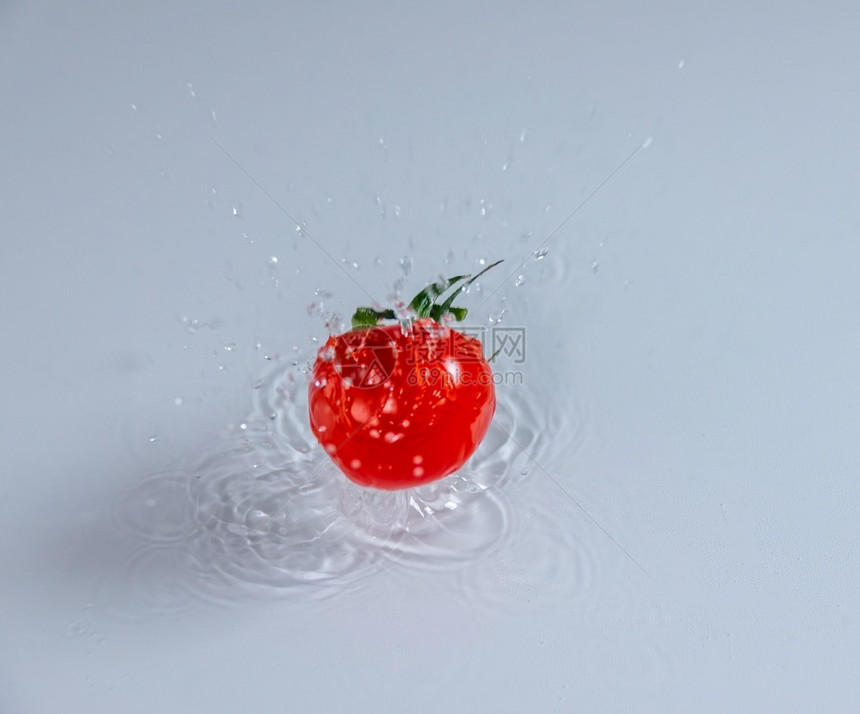 水果汁和成熟的樱桃西红柿进入水中产生大量花粉樱桃番茄和蒸汽水下降美味的图片